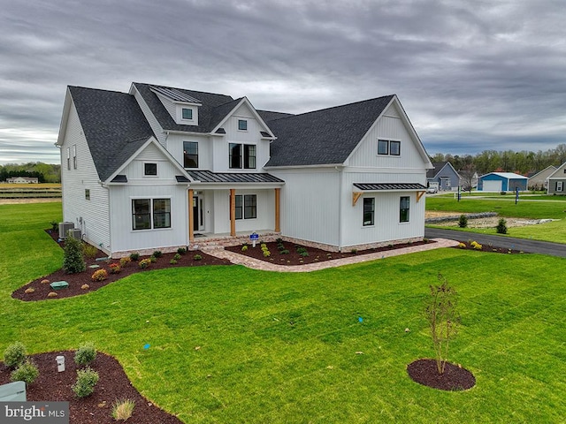 modern farmhouse with central air condition unit, a front lawn, and a porch