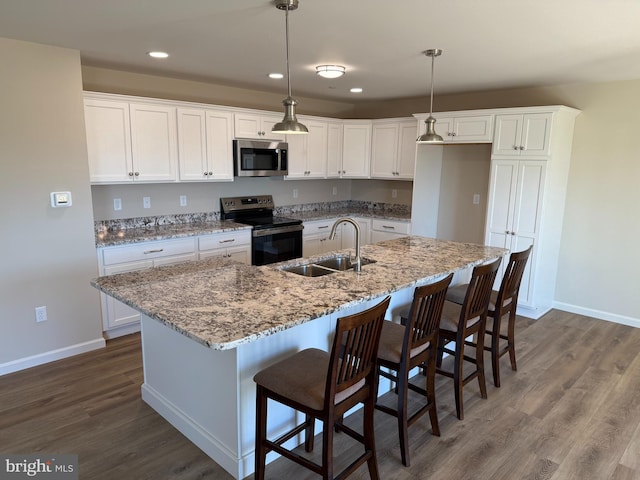 kitchen with stainless steel appliances, white cabinets, dark wood-type flooring, and a sink