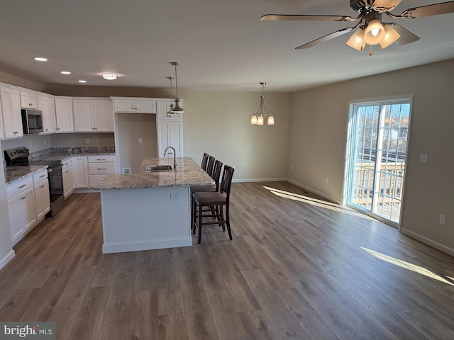 kitchen featuring stainless steel appliances, dark wood-style flooring, white cabinets, and a sink