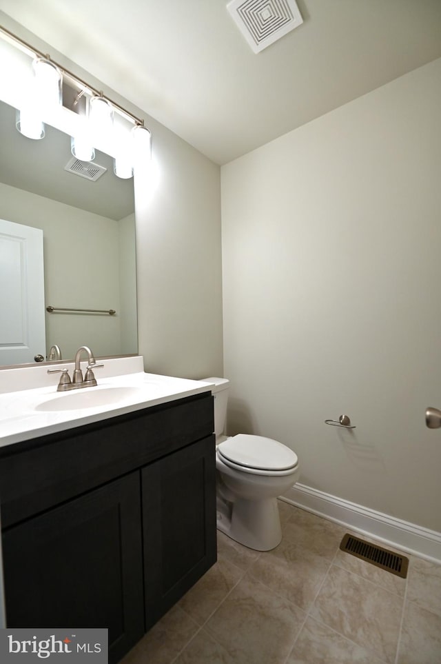 bathroom with toilet, tile floors, and vanity