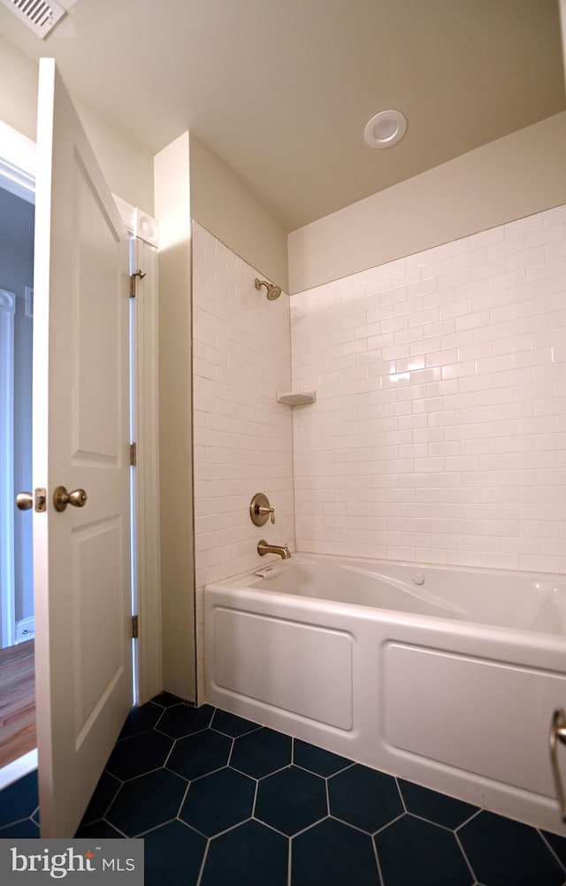 bathroom featuring tile flooring and tiled shower / bath