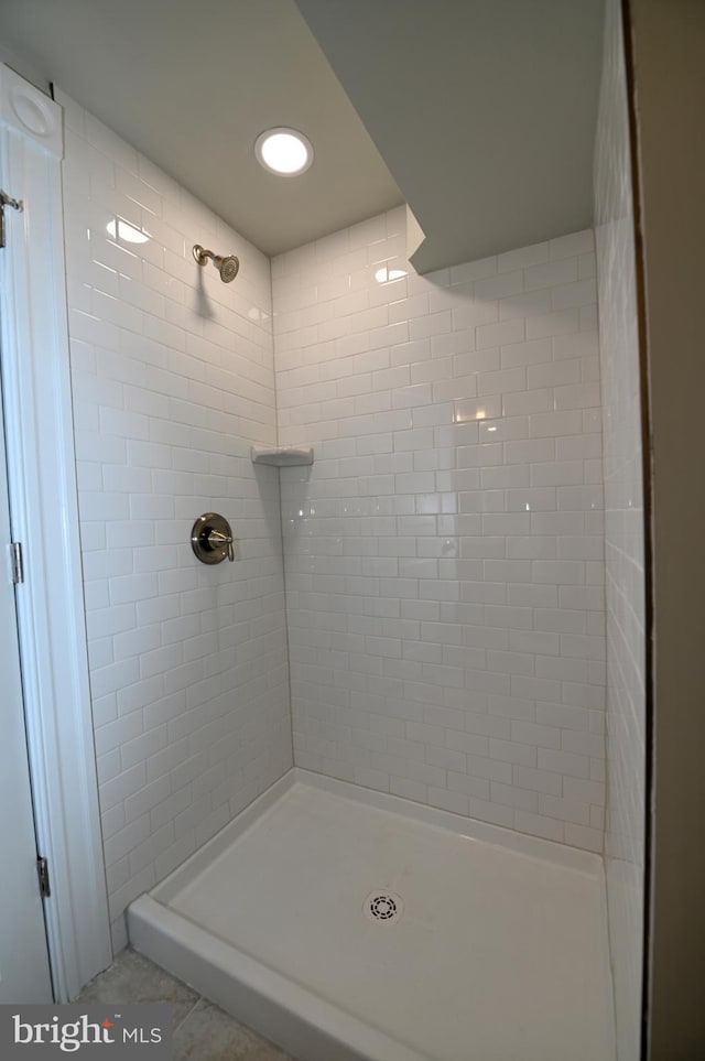 bathroom with tile flooring and tiled shower