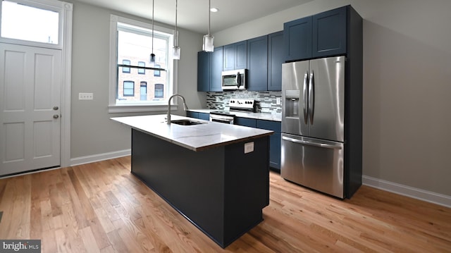 kitchen with sink, light hardwood / wood-style flooring, stainless steel appliances, a wealth of natural light, and pendant lighting