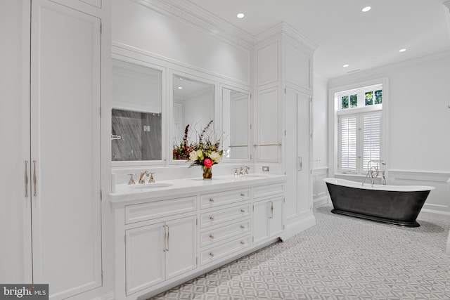 bathroom featuring vanity, crown molding, and a tub