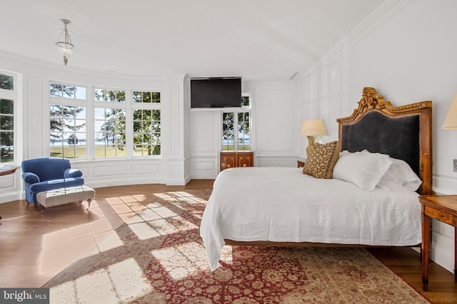 bedroom with wood-type flooring and crown molding