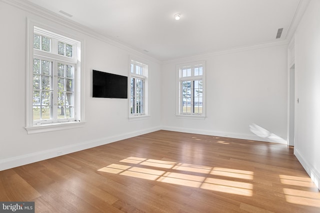 unfurnished room featuring ornamental molding, a healthy amount of sunlight, and light hardwood / wood-style floors