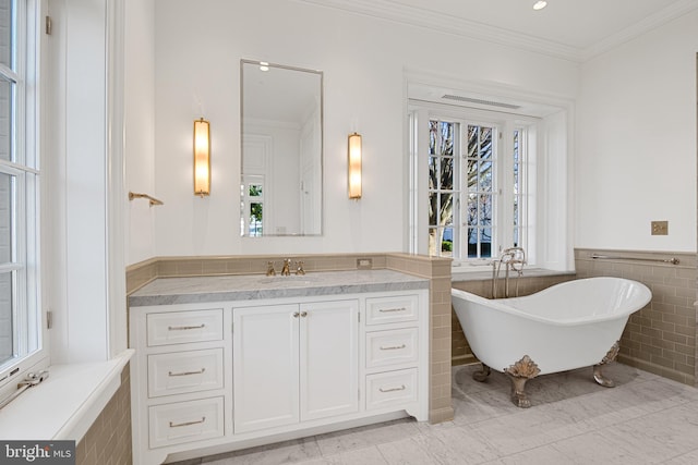 bathroom with a bathing tub, plenty of natural light, and tile walls