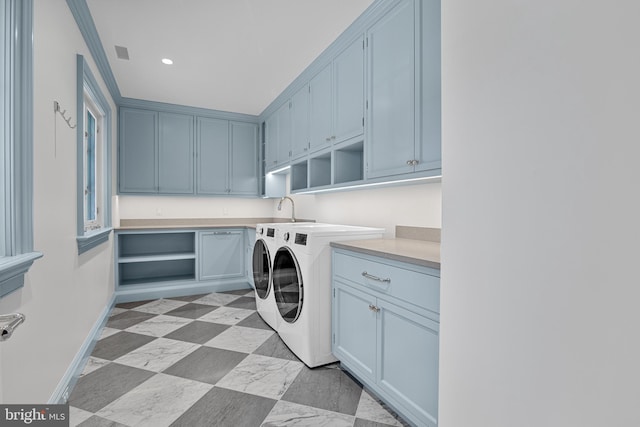 washroom featuring crown molding, washer and clothes dryer, and cabinets