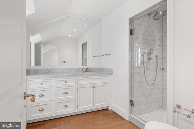 bathroom featuring hardwood / wood-style floors, vanity, a shower with shower door, and lofted ceiling