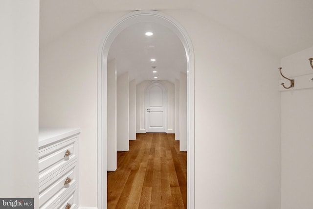 corridor featuring vaulted ceiling and light hardwood / wood-style flooring