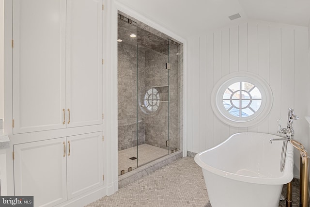 bathroom featuring tile patterned flooring, separate shower and tub, vaulted ceiling, and wood walls