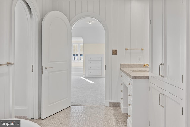 bathroom featuring wooden walls and vanity