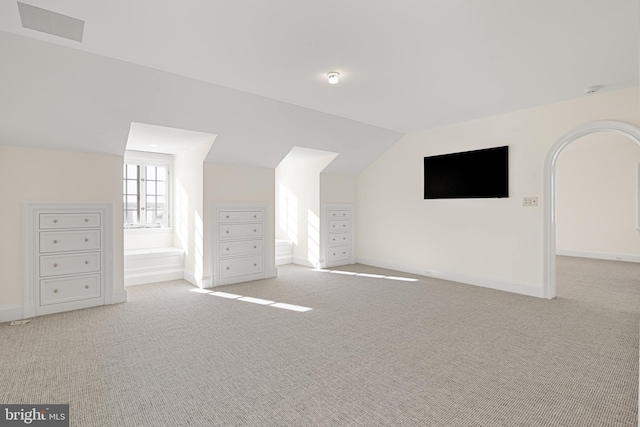 bonus room with light carpet and vaulted ceiling