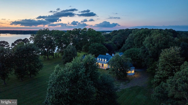 aerial view at dusk featuring a water view