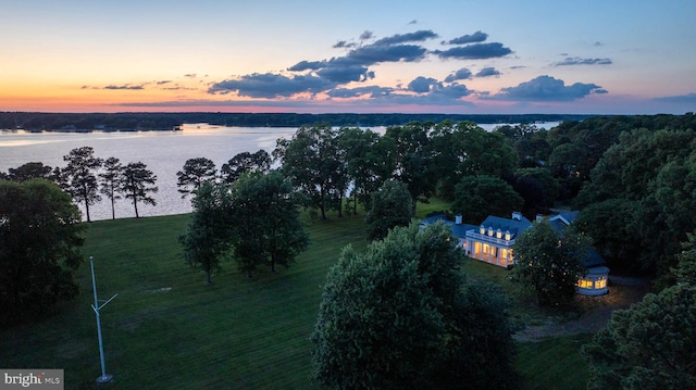 aerial view at dusk featuring a water view and a rural view