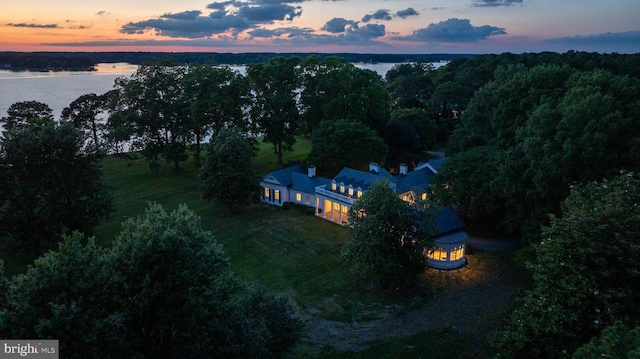 aerial view at dusk featuring a water view