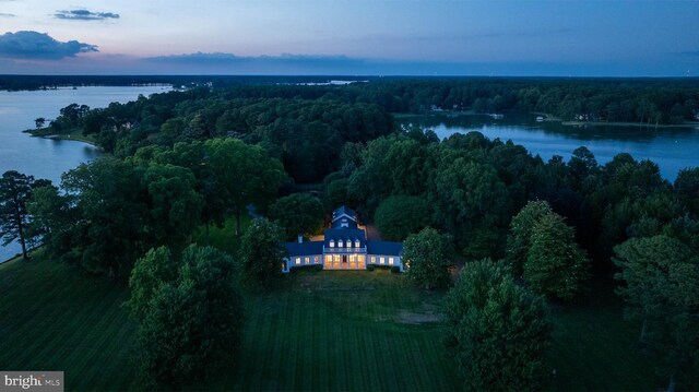 aerial view at dusk featuring a water view