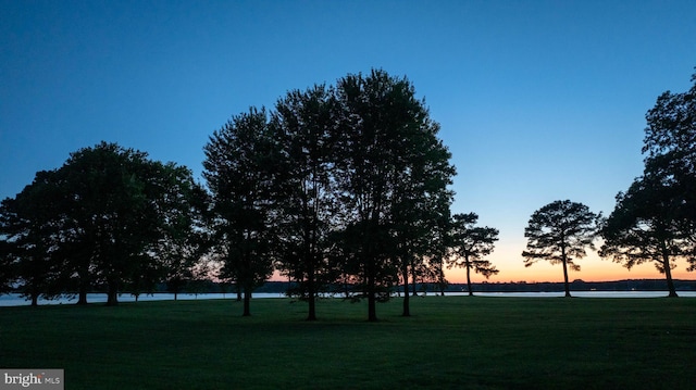 view of property's community with a lawn and a water view