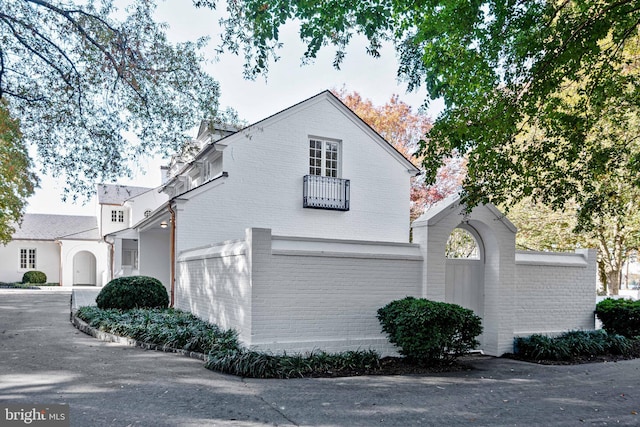 view of home's exterior featuring brick siding and a balcony