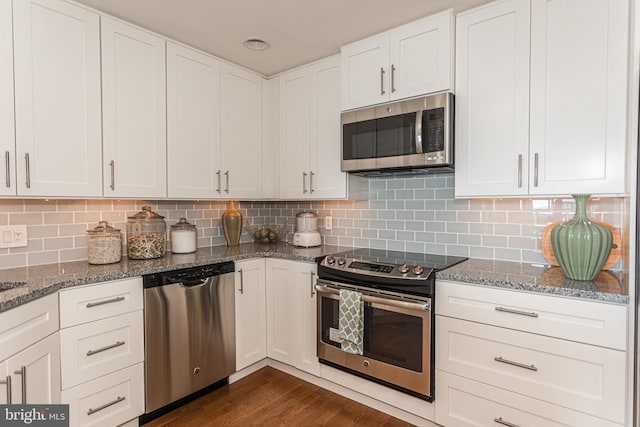 kitchen with decorative backsplash, white cabinets, and stainless steel appliances