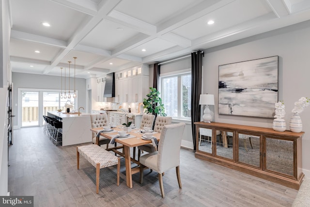 dining area featuring coffered ceiling, beam ceiling, and light hardwood / wood-style flooring