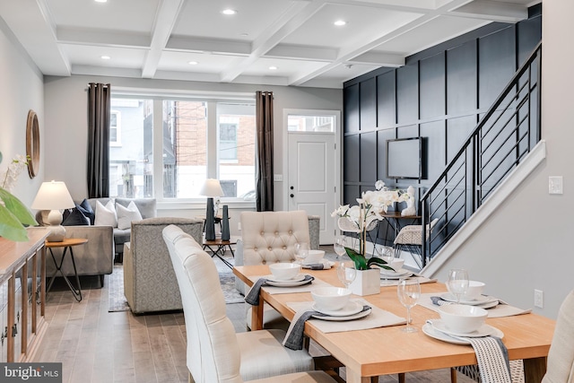 dining area with coffered ceiling, beam ceiling, a healthy amount of sunlight, and light hardwood / wood-style flooring