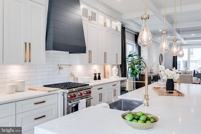 kitchen featuring white cabinets, premium stove, custom range hood, and backsplash