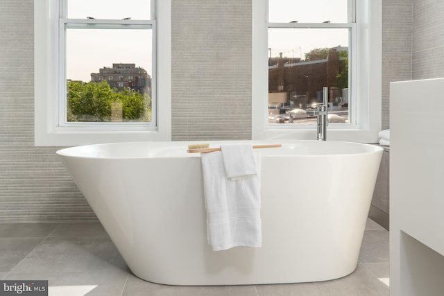 bathroom featuring tile walls, a wealth of natural light, and tile floors