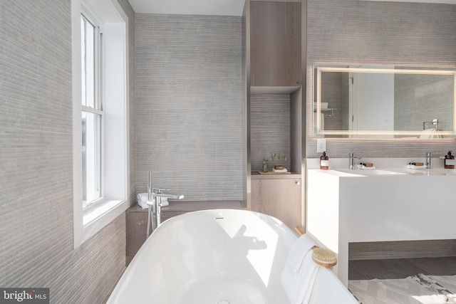 bathroom with tile walls, tile flooring, vanity, and a tub