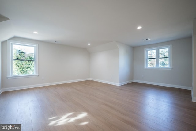 unfurnished room with light hardwood / wood-style floors and vaulted ceiling