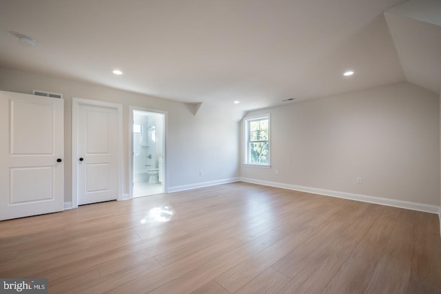 empty room with lofted ceiling and light hardwood / wood-style flooring