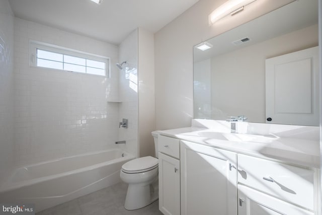 full bathroom with oversized vanity, toilet, tile floors, and tiled shower / bath