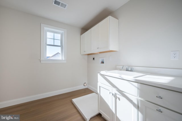 laundry room featuring washer hookup, hookup for an electric dryer, cabinets, hardwood / wood-style floors, and sink