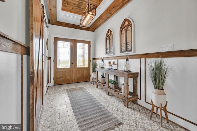 foyer with french doors, wood ceiling, and light tile floors