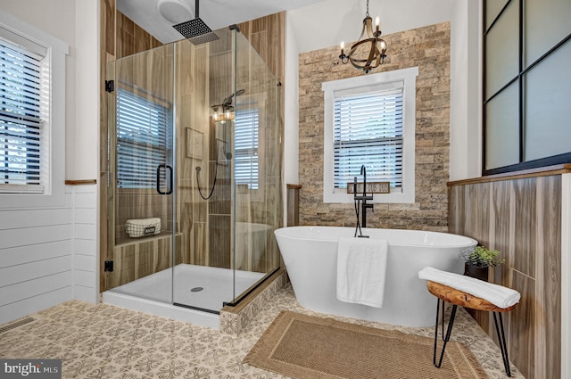 bathroom with a notable chandelier, tile floors, and independent shower and bath