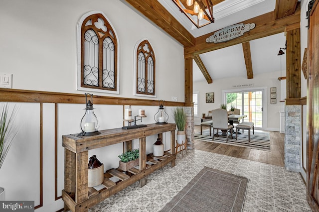 hall featuring a barn door, hardwood / wood-style floors, a notable chandelier, and lofted ceiling with beams