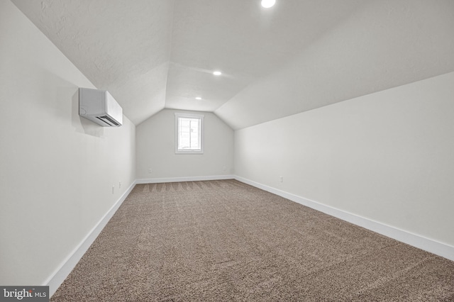 bonus room featuring carpet flooring, an AC wall unit, and vaulted ceiling