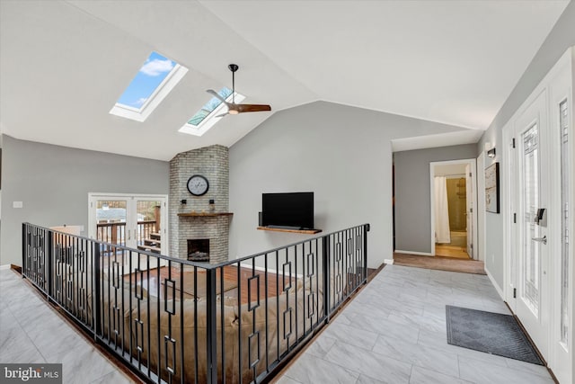 hallway with vaulted ceiling with skylight