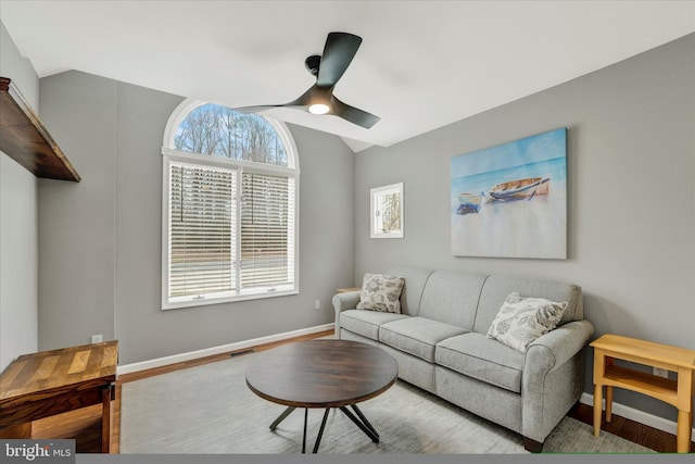 living area with vaulted ceiling, wood finished floors, visible vents, baseboards, and ceiling fan
