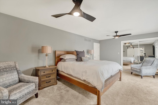 bedroom with light carpet, a ceiling fan, and visible vents