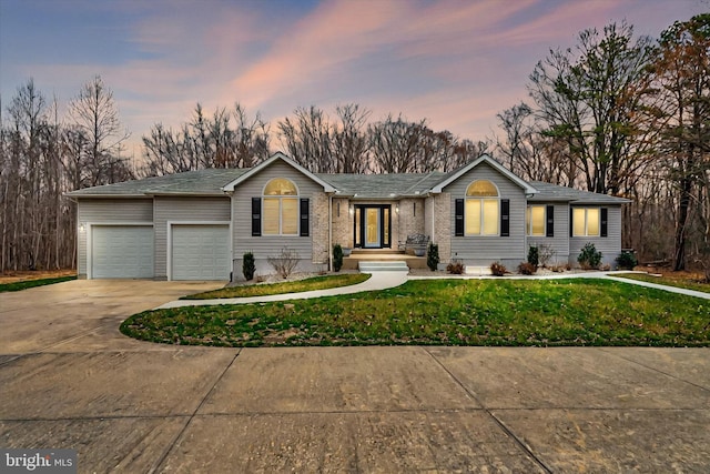 single story home with a lawn, driveway, and a garage