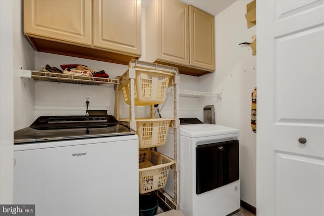 clothes washing area featuring cabinet space and washer and clothes dryer