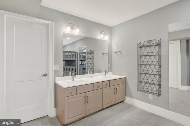 full bathroom with baseboards, a sink, double vanity, and carpet