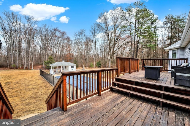 wooden terrace featuring an outbuilding and an outdoor fire pit