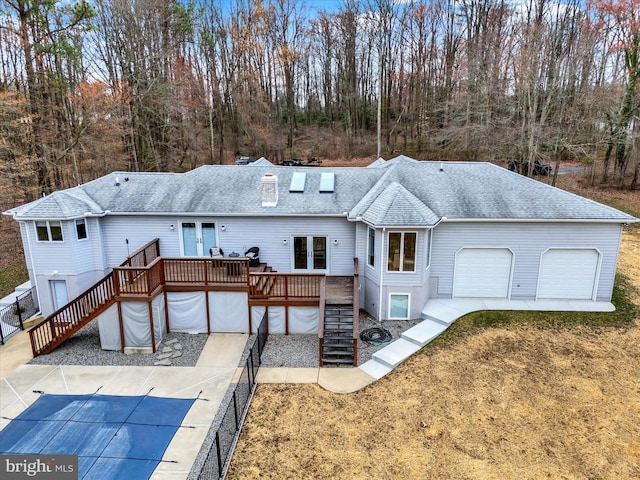 back of property with stairway, a shingled roof, french doors, and a deck