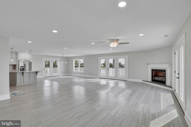 unfurnished living room with french doors and ceiling fan