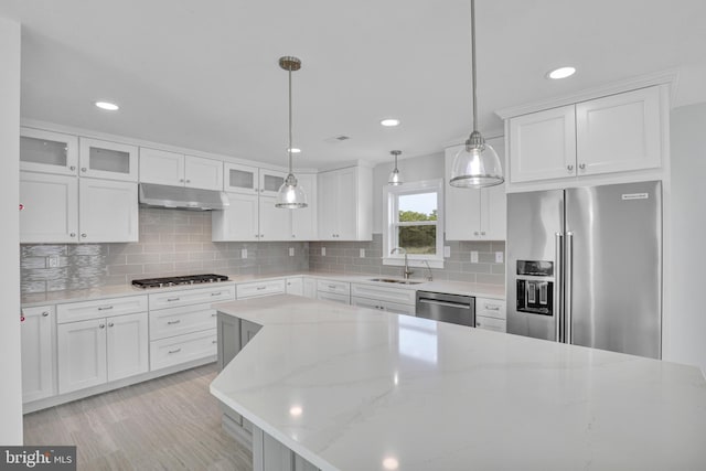 kitchen with backsplash, pendant lighting, and white cabinetry