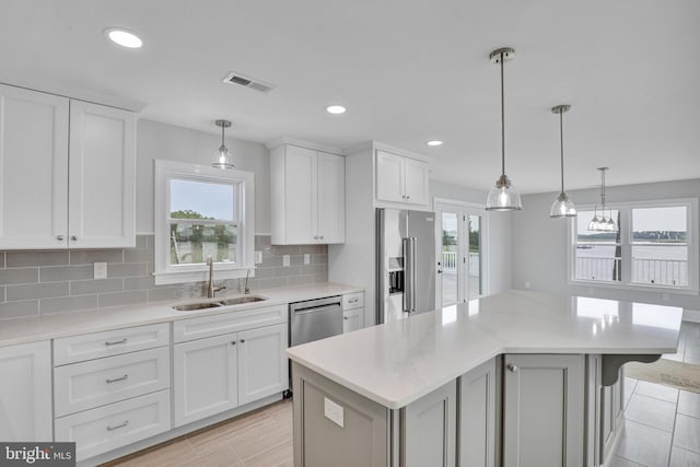 kitchen with tasteful backsplash, stainless steel appliances, sink, and a wealth of natural light