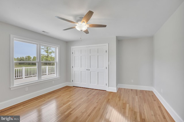 unfurnished bedroom with light hardwood / wood-style floors, a closet, and ceiling fan