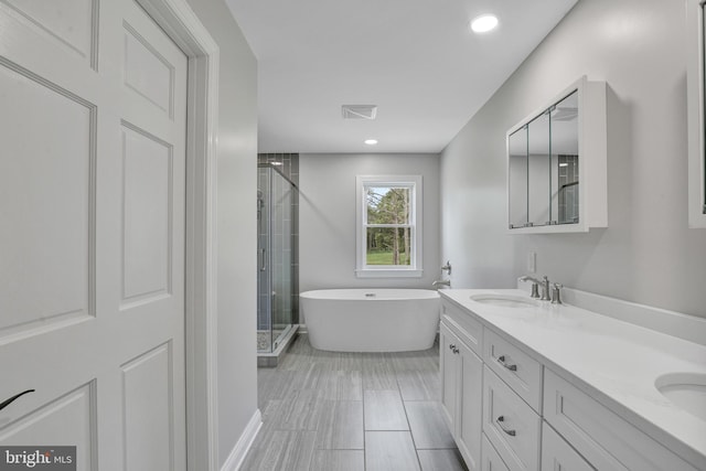 bathroom with double sink vanity, tile flooring, and plus walk in shower